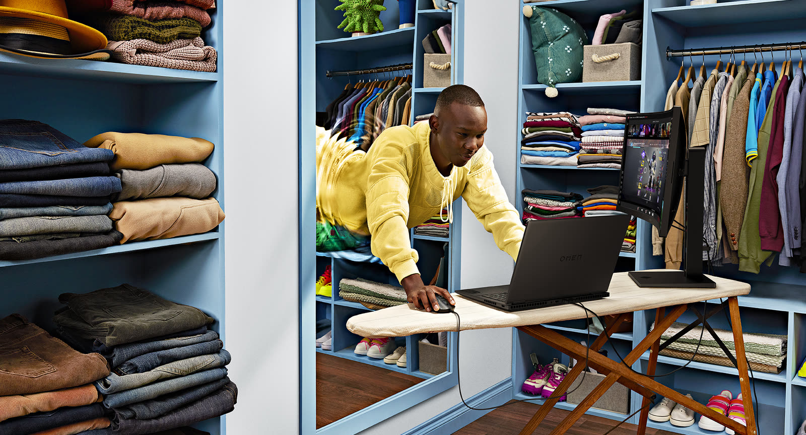 On set for HP: a man ironing in a blue closet with a laptop on the board